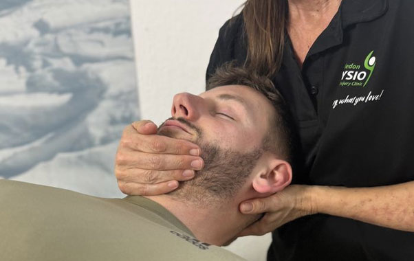 Physiotherapist providing neck treatment